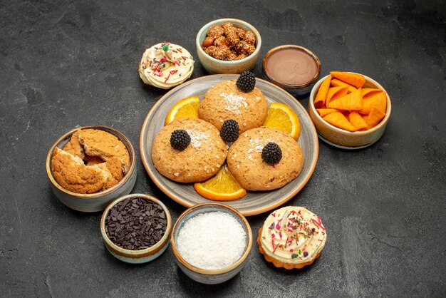 Вид спереди сахарное печенье с дольками апельсина и чипсы на темном фоне печенье, печенье, сладкий чайный торт