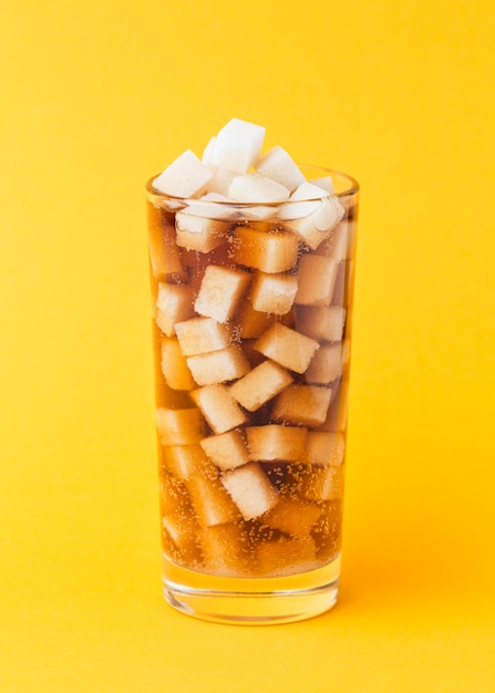 Вид спереди кубиков сахара в стакане с безалкогольным напитком