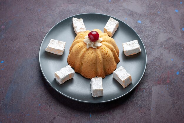 Front view sugar powdered candies delicious nougat with cake inside plate on dark surface