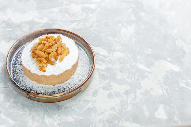 Front view sugar powdered raisins dried grapes on top of little cake inside plate on white desk raisin fruit sugar sweet cake biscuit pie