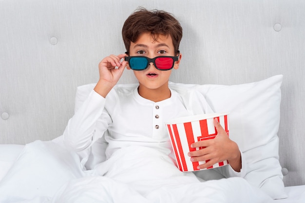 Front view surprised boy while watching movie