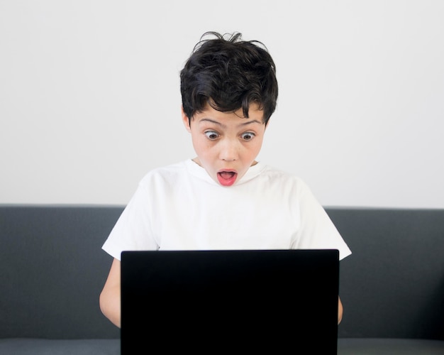 Front view surprised boy with laptop