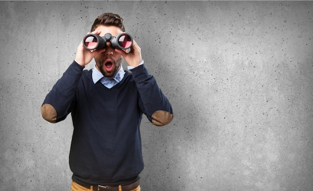 Free photo front view of surprised guy with binoculars