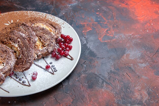 Foto gratuita il biscotto dolce di vista frontale rotola le torte cremose affettate sulla tavola scura