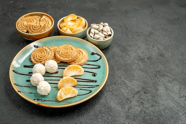 Free photo front view sweet biscuits with coconut candies on a grey desk biscuit cookie sweet