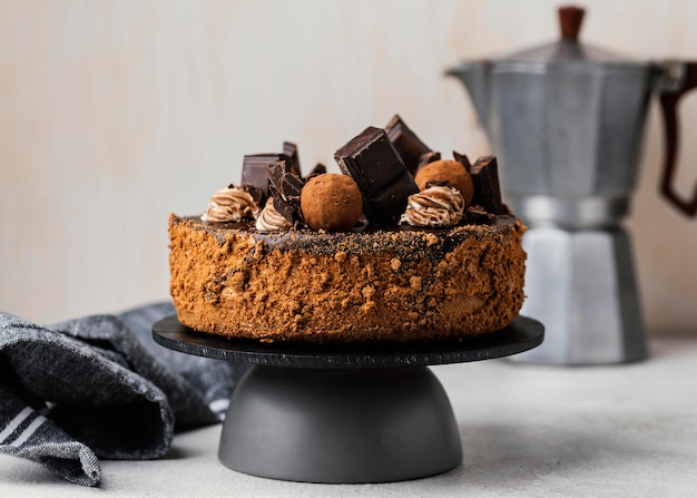 Front view of sweet chocolate cake on stand with kettle