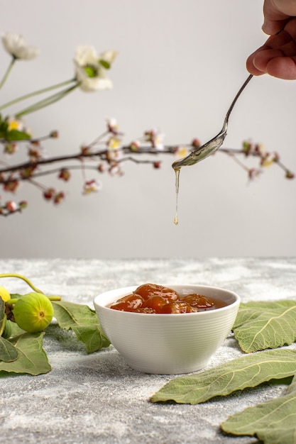 Front view sweet figs jam with flowers on white surface