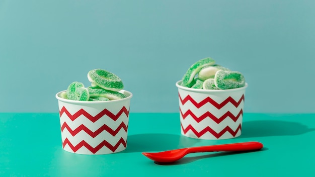 Front view of sweet jelly in cups with spoon