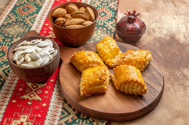 Сладкие ореховые пирожные с орехами на коричневом столе, вид спереди