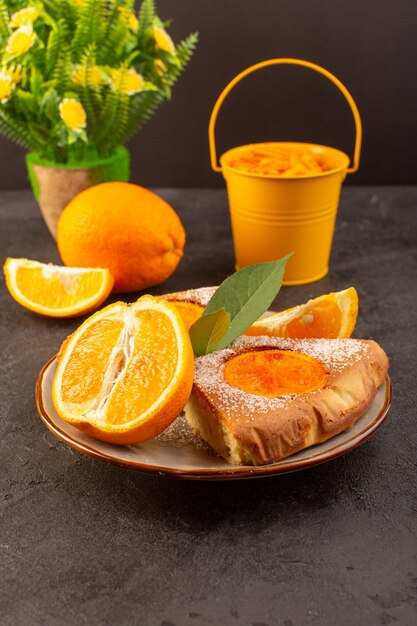Вид спереди сладкий апельсиновый пирог сладкие вкусные кусочки пирога вместе с нарезанным апельсином внутри круглой пластины на сером фоне печенье сладкий сахар