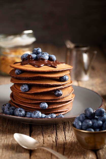 Front view sweet pancakes on plate with blueberries