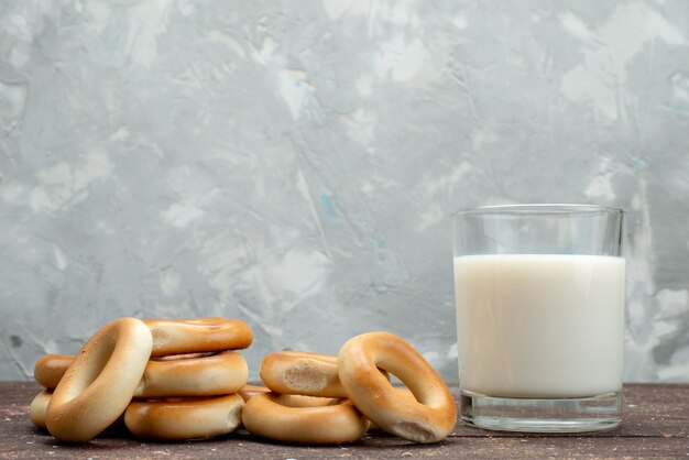 正面の甘い丸いクッキーは白で冷たい牛乳のガラスと共に乾燥し、クッキービスケットドリンクの朝食
