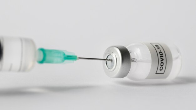 Вид спереди на шприц и бутылку с вакциной