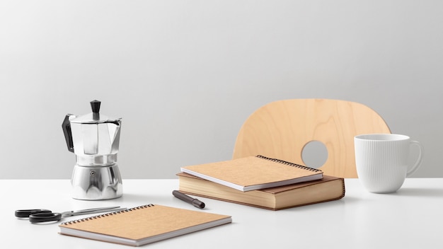 Front view of table with notebooks and kettle