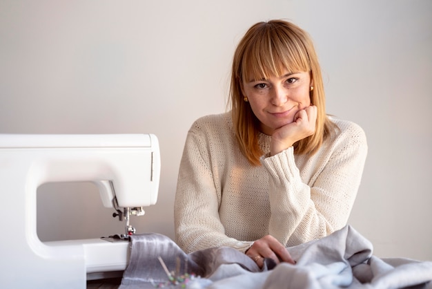 Foto gratuita donna su misura vista frontale utilizzando la macchina da cucire