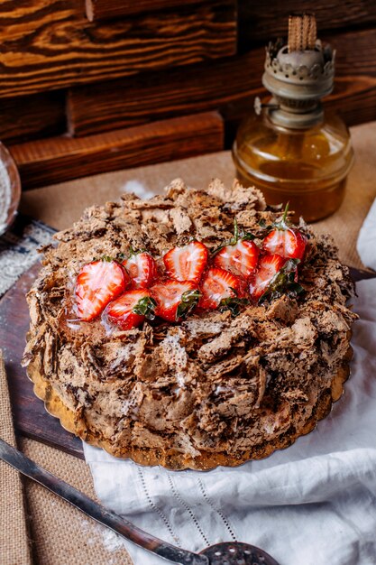 갈색 바닥에 초콜릿과 신선한 빨간 얇게 썬 딸기와 전면보기 맛있는 케이크