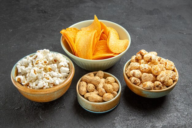 Front view tasty cheese cips with different snacks on dark background