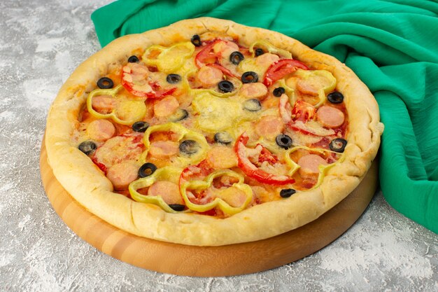 Вид спереди вкусная сырная пицца с сосисками из черных оливок и красными помидорами на сером