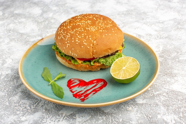 Free photo front view tasty chicken sandwich with green salad and vegetables inside plate with lemon on white desk.