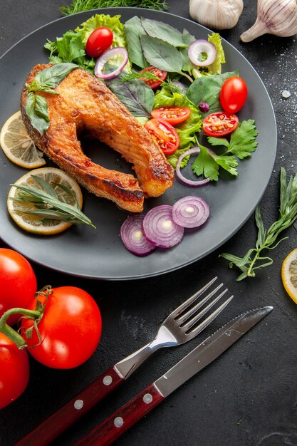 Вид спереди вкусная приготовленная рыба со свежими овощами на темном фоне блюдо из морепродуктов, цвет мяса