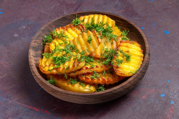 Бесплатное фото Вид спереди вкусный приготовленный картофель с зеленью внутри тарелки на темной поверхности, чипсы для приготовления ужина, еда, картофель