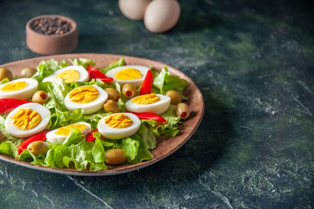 front view tasty egg salad consists of olives and green salad on dark background