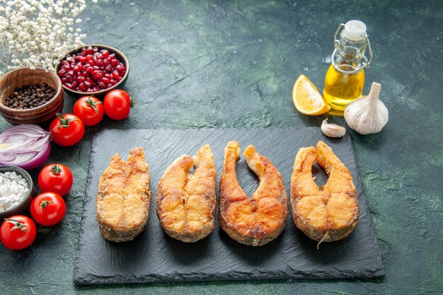 Вид спереди вкусная жареная рыба с помидорами на темной поверхности приготовление блюда еда салат жареная еда морепродукты перец морепродукты