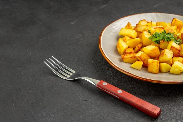 Vista frontale gustose patate fritte all'interno del piatto con verdure sul tavolo scuro Foto Gratuite
