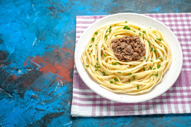 青い生地の料理の食事の食べ物にひき肉を入れた正面のおいしいイタリアン パスタ