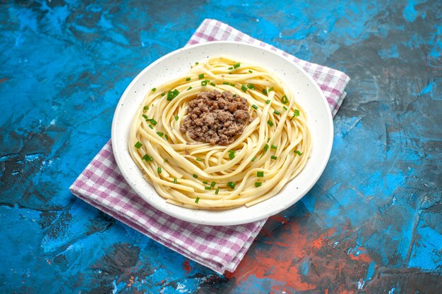 青い生地の料理の肉の色の食事の食べ物にひき肉を入れた正面のおいしいイタリアン パスタ