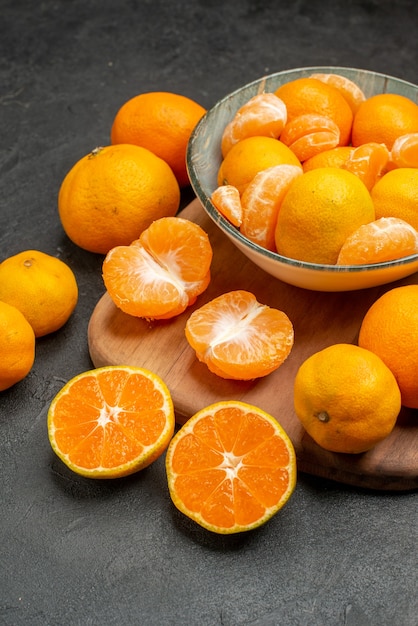 Front view tasty juicy tangerines inside plate on a grey background exotic citrus fruit color photo sour orange