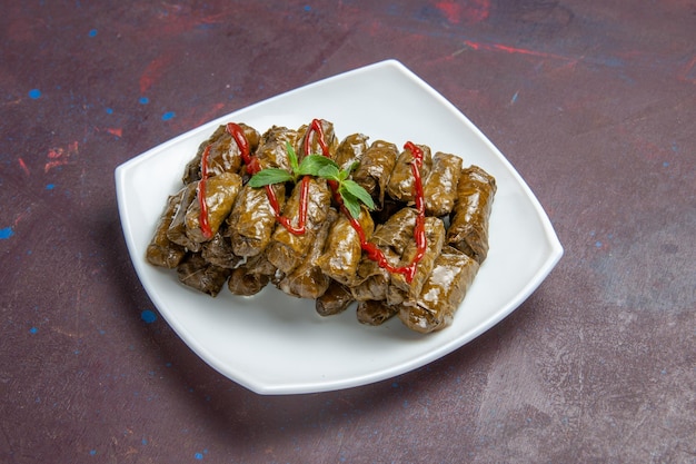 Front view tasty leaf dolma ground meat dish inside plate on dark space