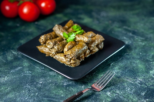 Вид спереди вкусная листовая долма с помидорами на темном фоне калорийность масла ужин еда салат блюдо мясо ресторан еда