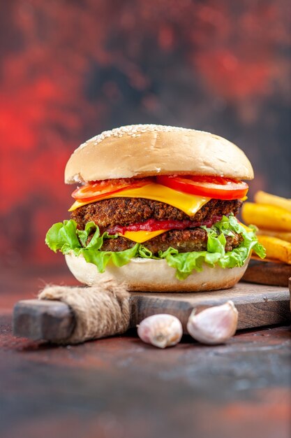 Front view tasty meat burger with french fries on dark background