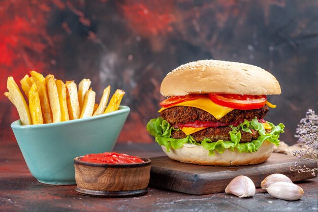 Front view tasty meat burger with french fries on dark desk