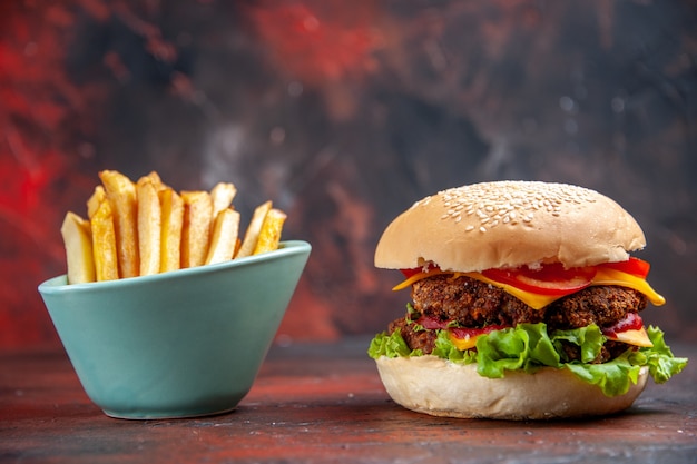 Front view tasty meat burger with fries on dark background