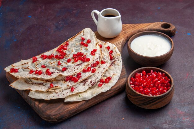 진한 보라색 표면 음식 고기 반죽에 신선한 붉은 석류와 함께 전면보기 맛있는 고기 qutabs pitas