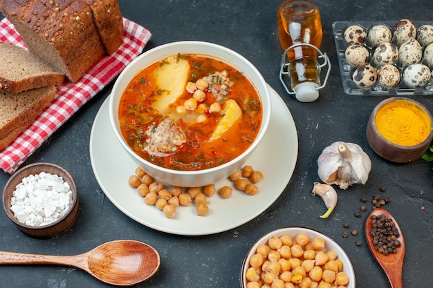 正面図おいしい肉スープは、暗いテーブルの上にジャガイモの肉と豆で構成されています