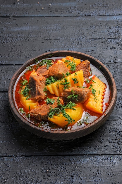 Foto gratuita vista frontale gustosa zuppa di carne con patate e verdure sulla salsa di piatto di carne pasto scuro scrivania