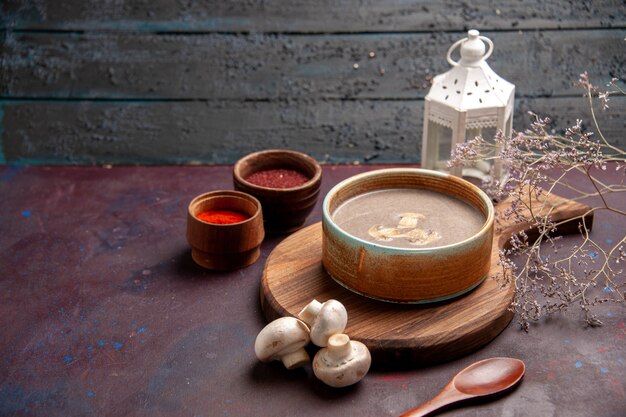 暗い空間にさまざまな調味料を使ったおいしいキノコのスープを正面から見る