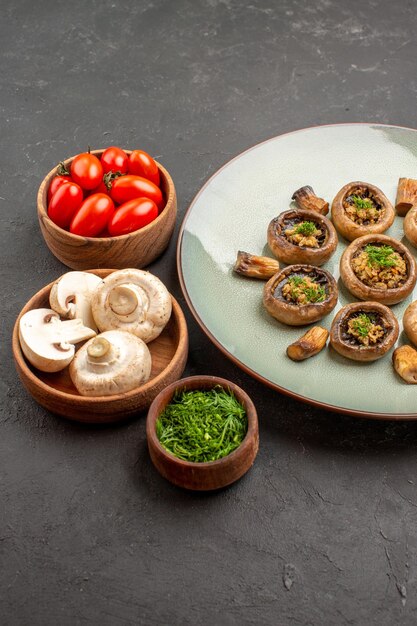Front view tasty mushrooms meal with fresh greens and tomatoes on a dark background dish dinner meal cooking mushroom