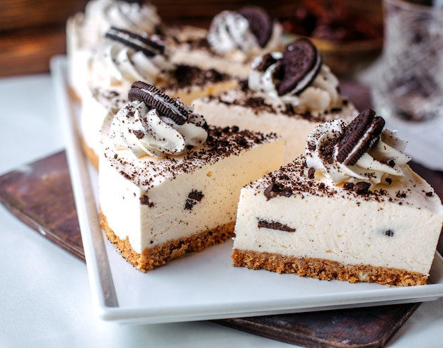 茶色の表面の白いプレート内の正面のおいしいオレオチーズケーキ
