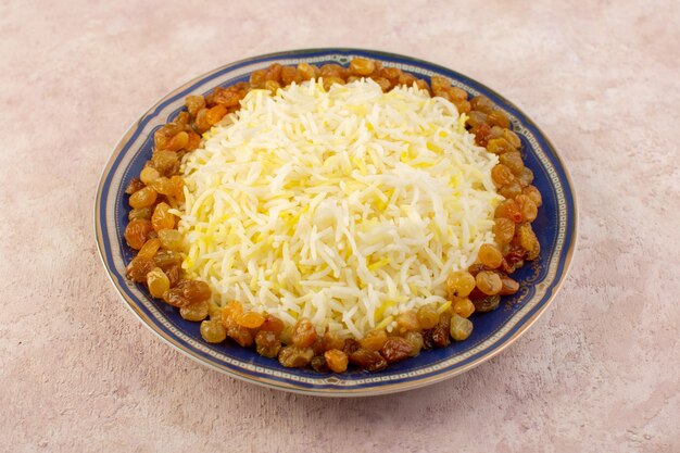 Front view of tasty pilaf with oil and dried raisins inside plate on the pink surface