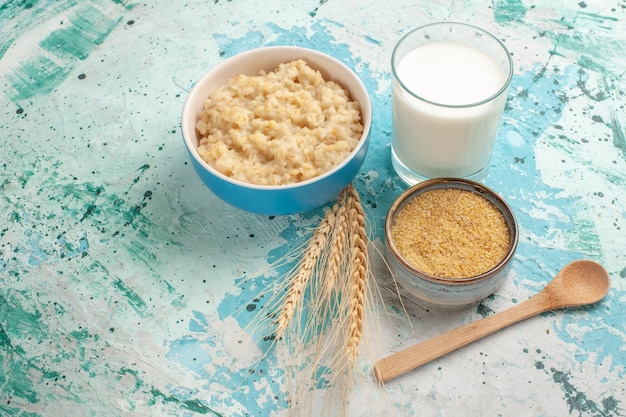 Front view tasty porridge with milk on blue desk breakfast meal food milk