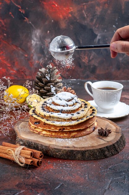 Front view tasty sweet pancakes with sugar powder on dark background