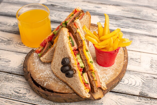 Front view tasty toast sandwiches with cheese ham inside with french fries juice on wood