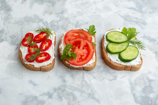 Front view tasty toasts with tomatoes peppers and cucumbers on white background sandwich bread food meal dinner burger horizontal