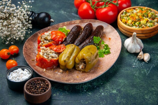 front view tasty vegetable dolma with tomatoes on blue background