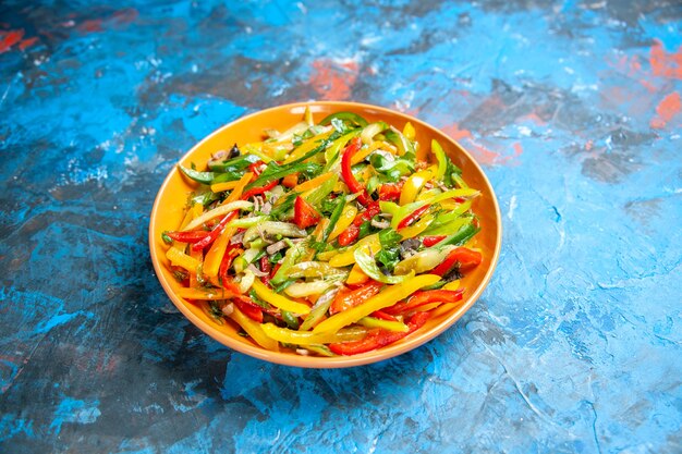 Front view tasty vegetable salad inside plate on a blue table