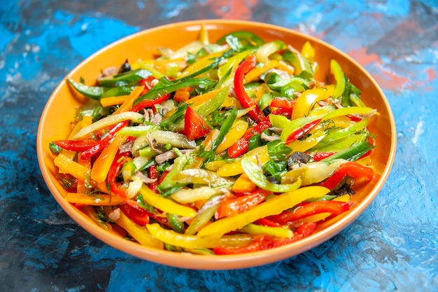 Front view tasty vegetable salad inside plate on blue table